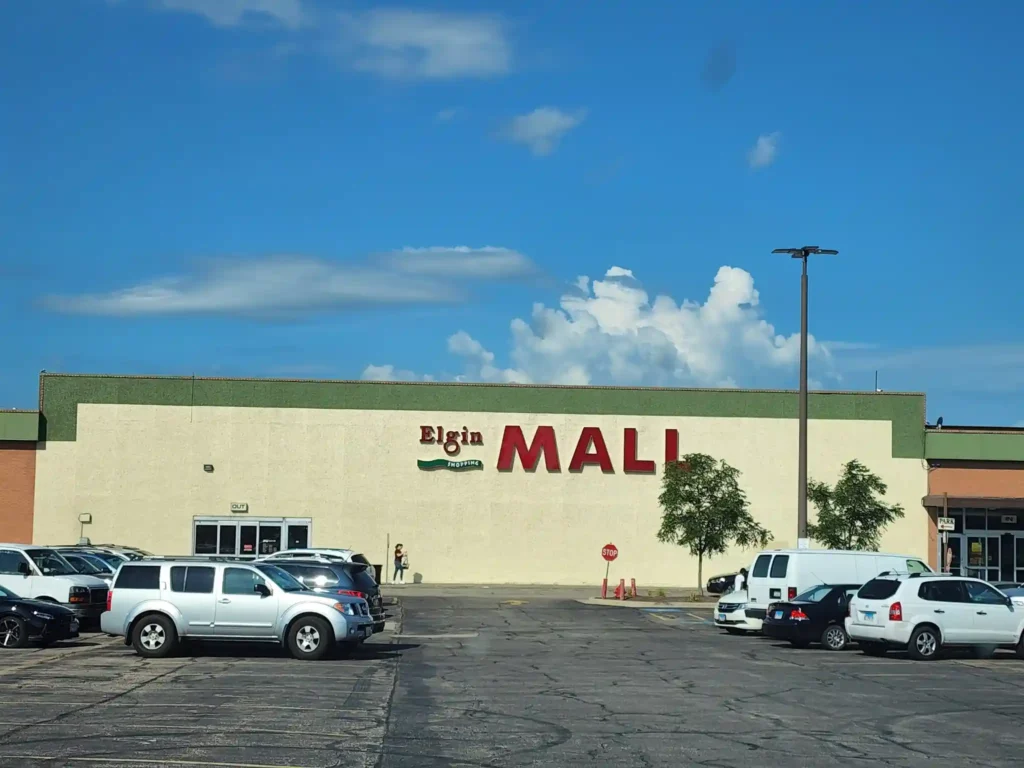 A bustling store with rows of parked cars in front