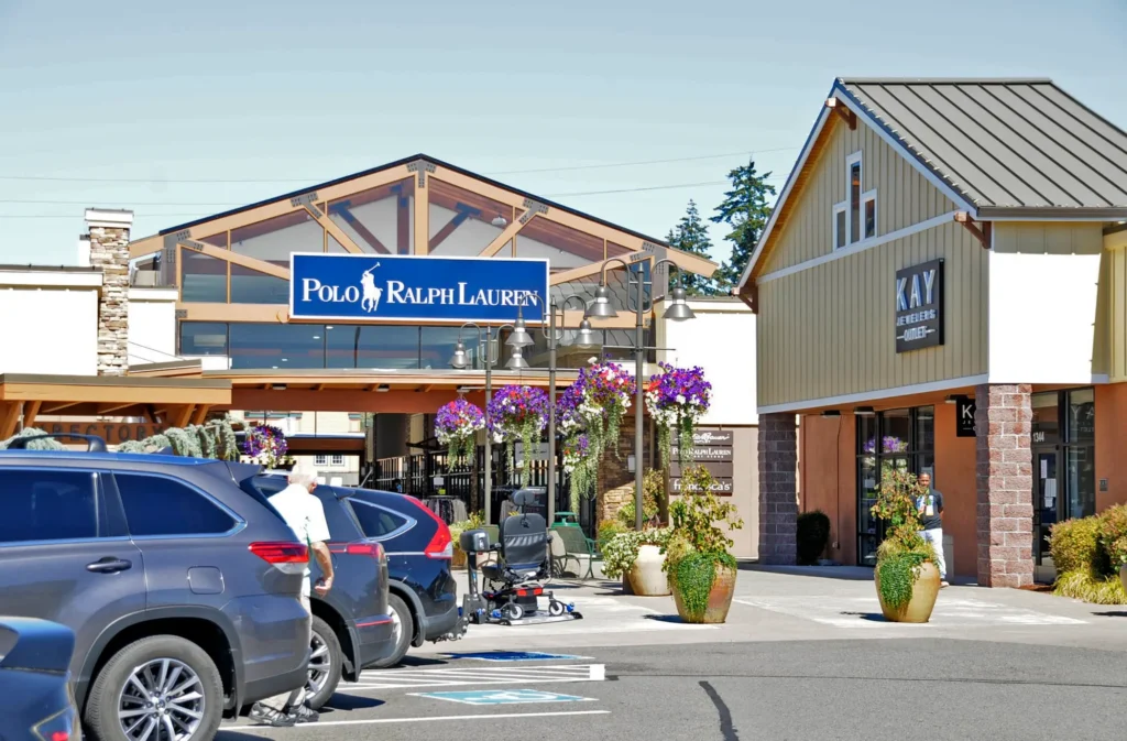 A parking lot at Centralia Outlets filled with parked cars, providing ample space for shoppers.