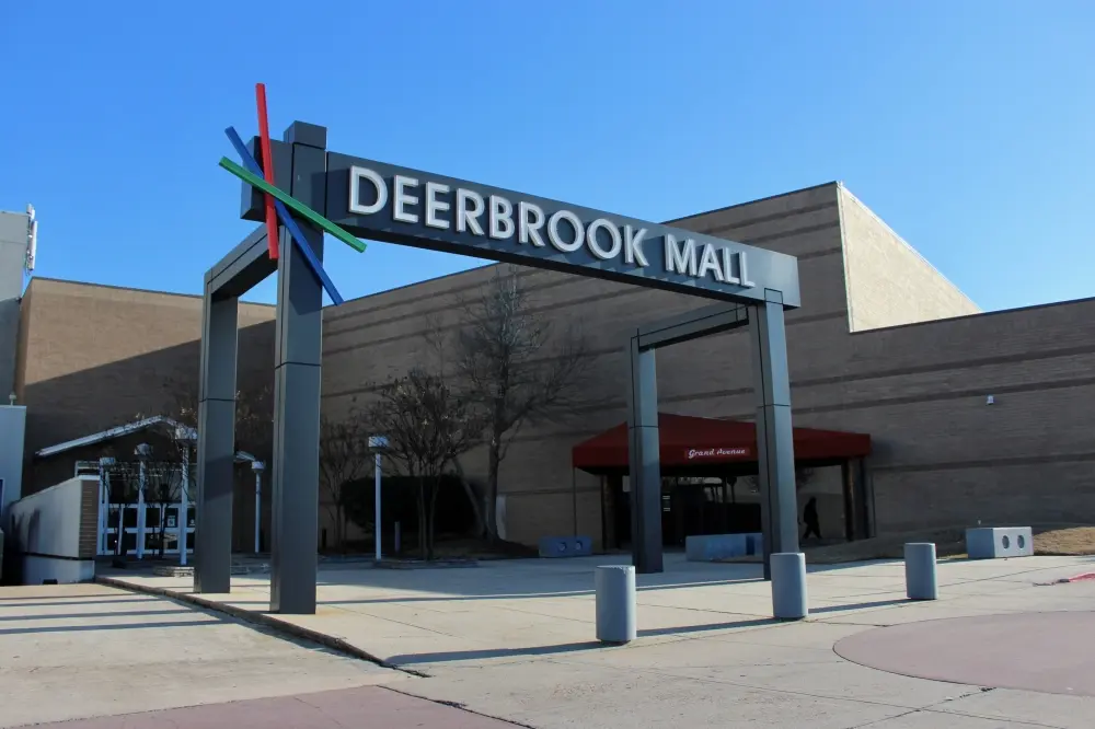 Exterior of Deerbrook Mall with large glass windows and colorful signage.