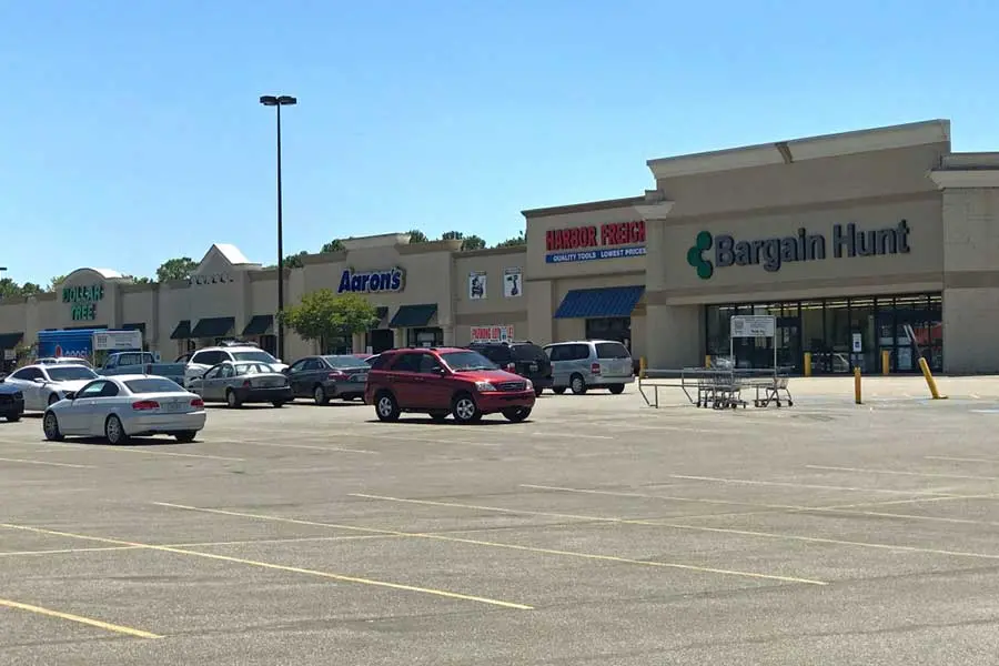 Exterior of Gadsden Mall with various stores and people walking around.