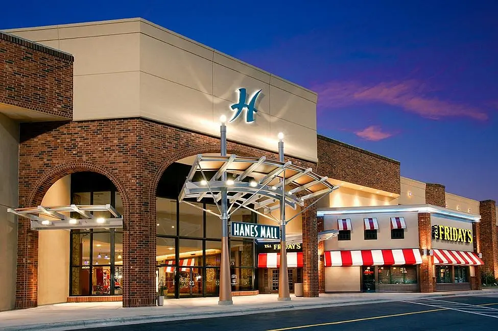 Large brick building with red and white awning at Hanes Mall.