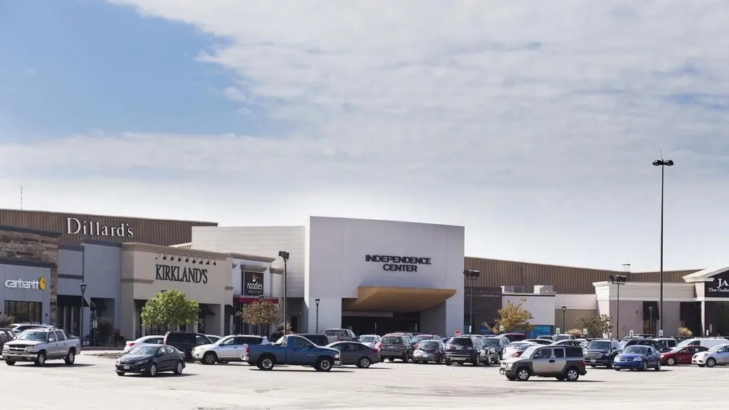 Exterior of Independence Center shopping mall with people walking in and out of various stores.