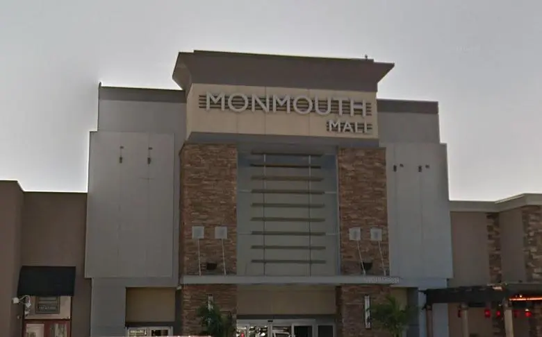 Exterior of Monmouth Mall with various stores and people walking around.