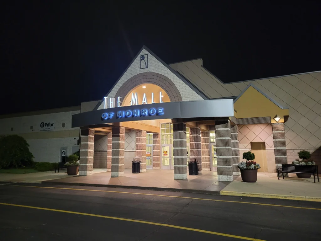 Exterior of Monroe Mall with colorful storefronts and bustling shoppers.