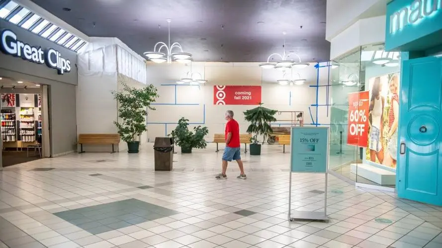 A man walking through Palouse Mall with a sign.