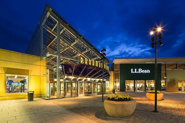 A modern shopping mall featuring a wide range of stores, bustling crowds, and a vibrant ambiance.