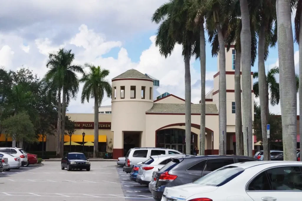 A parking lot at Pembroke Lakes Mall with multiple cars parked in front of a building.