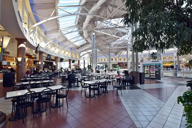 Exterior of Provo Towne Centre with people walking and shopping on a sunny day.