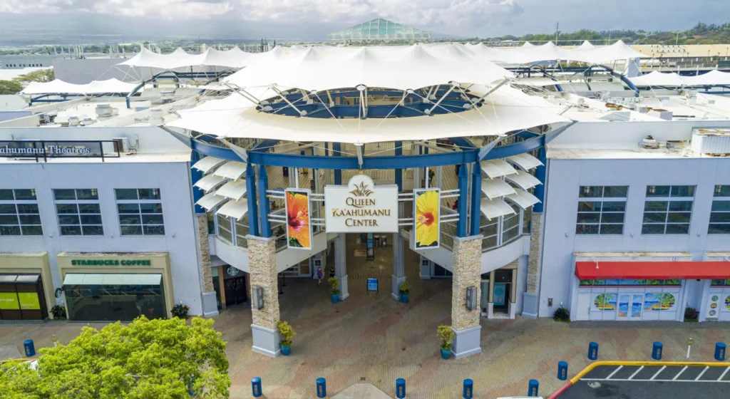 A bustling mall with various stores and shoppers browsing through merchandise.