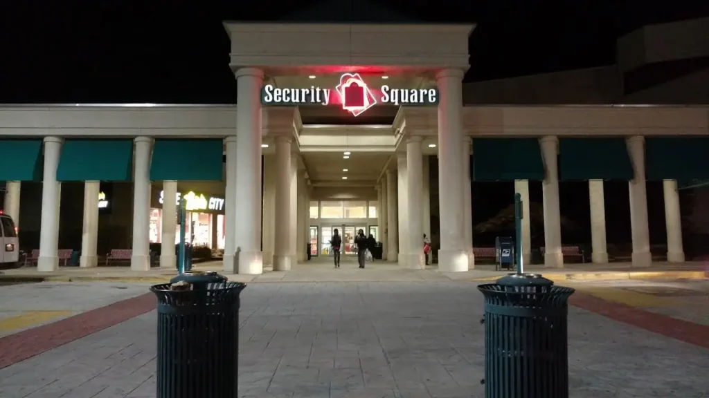 A modern security square with surveillance cameras, metal detectors, and security guards.