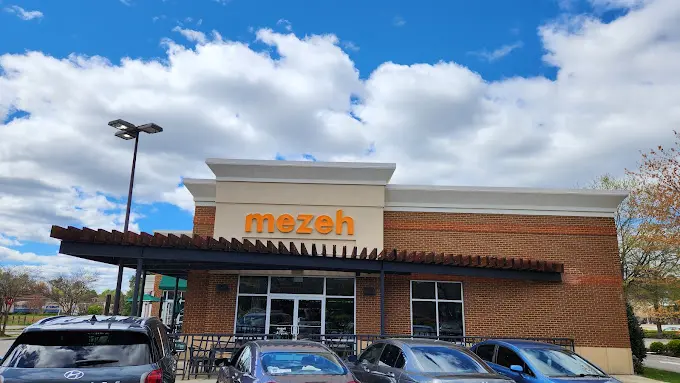 Facade at Short Pump Town Center with vehicles parked outside.