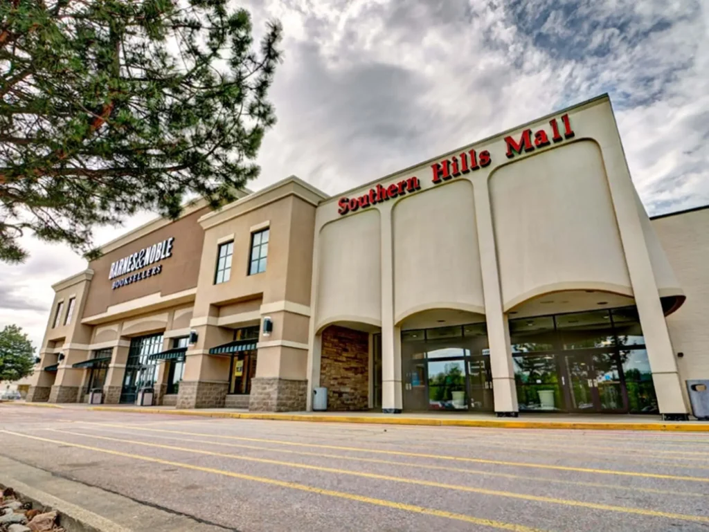 Exterior of Southern Hills Mall with various stores and shoppers walking around.