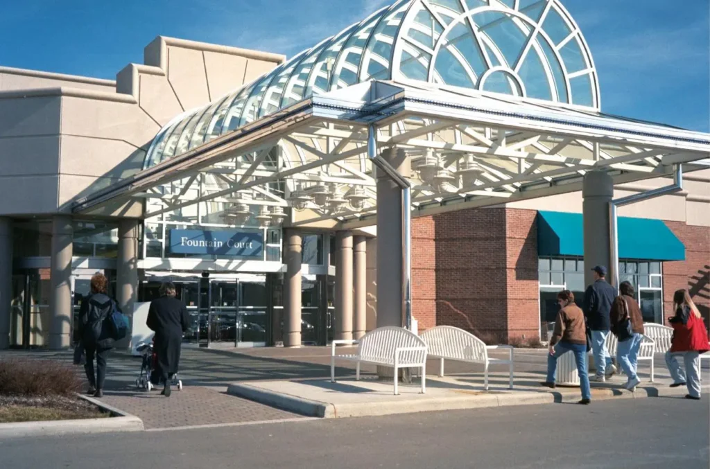 Exterior view of The Mall at Tuttle Crossing with people walking around and various stores visible.