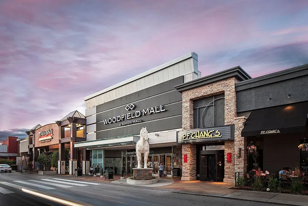 A street view of Woodfield Mall with a statue in the middle.