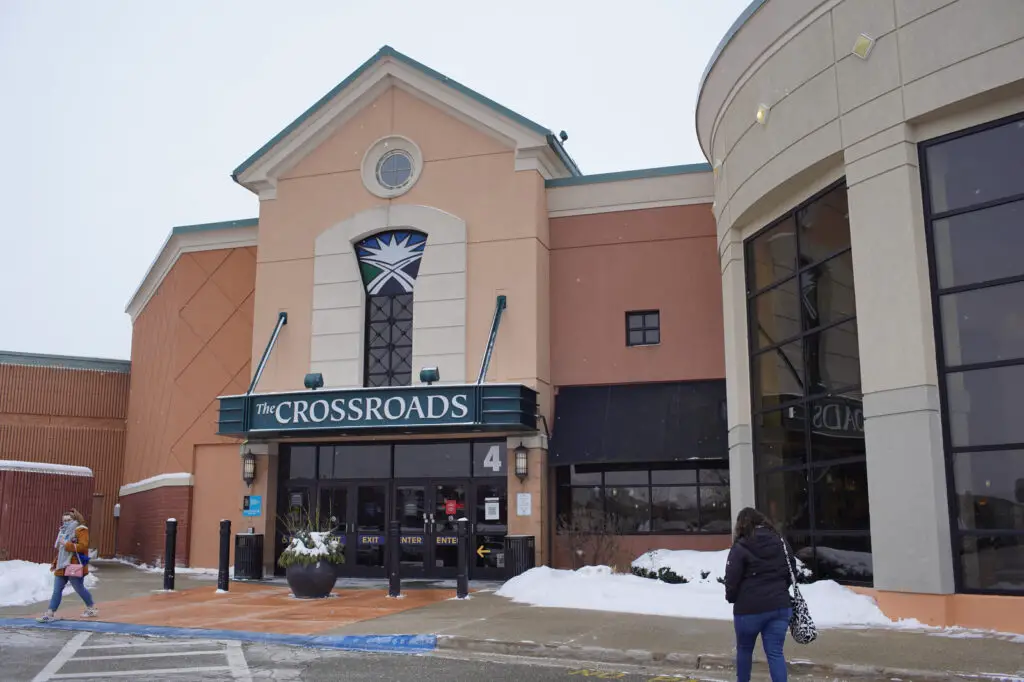 Discover the vibrant energy of Crossroads Mall as a woman gracefully walks by, showcasing the shopping center's lively ambiance.