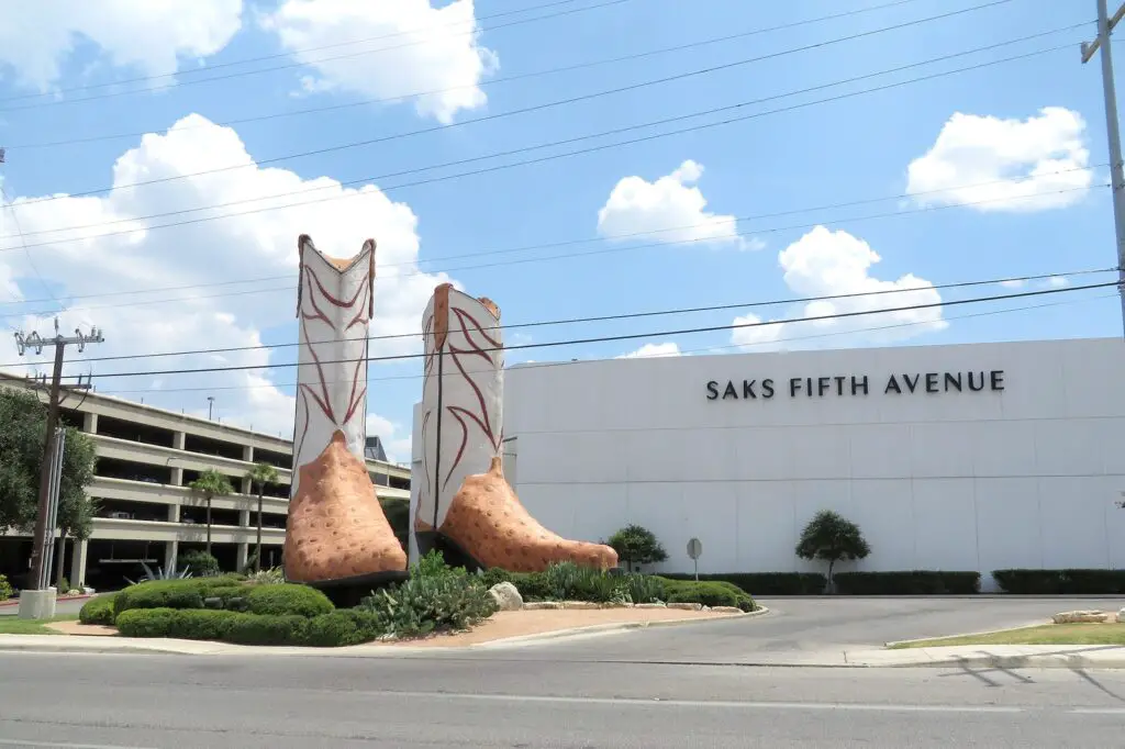 Behold the magnificent cowboy boot statue, guarding the entrance of a vibrant shopping mall, inviting you to explore a world of retail delights.