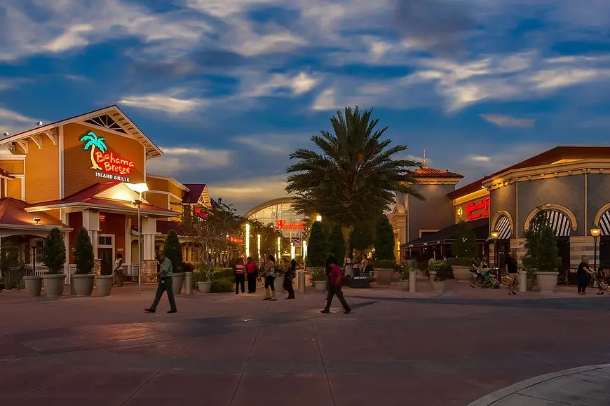 . Shopping center at Disney's Epcot, featuring colorful storefronts and bustling crowds.