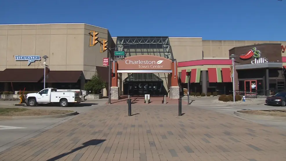 A bustling shopping center named "Cottonwood Mall" with a prominent sign, offering a wide range of retail options.