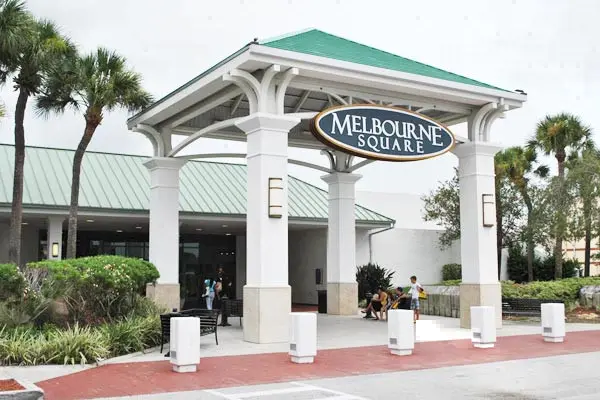 Entrance to shopping center with palm trees, creating a tropical vibe for visitors.