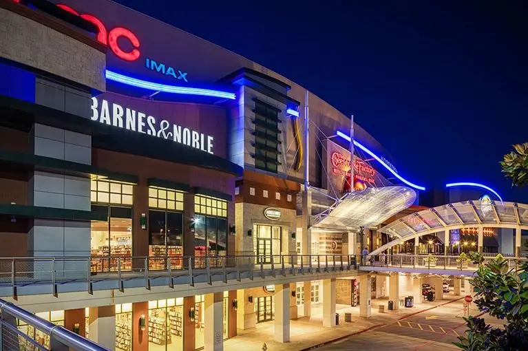 A bustling shopping center illuminated by vibrant lights during the night.