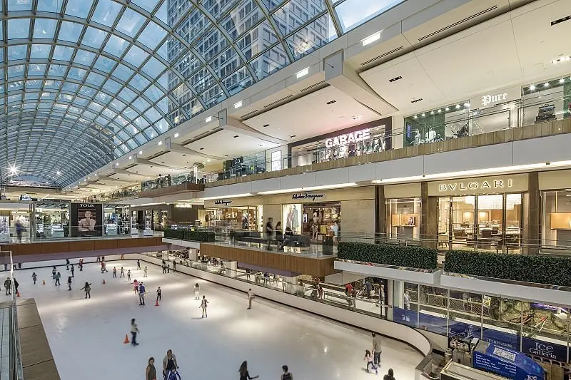 An indoor shopping mall with people gracefully gliding on the ice rink, enjoying a fun-filled day of ice skating.