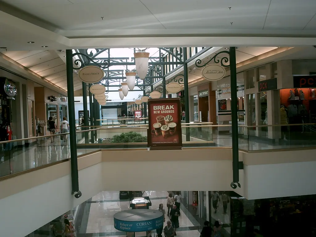 A mall with a sign displaying various stores and brands.