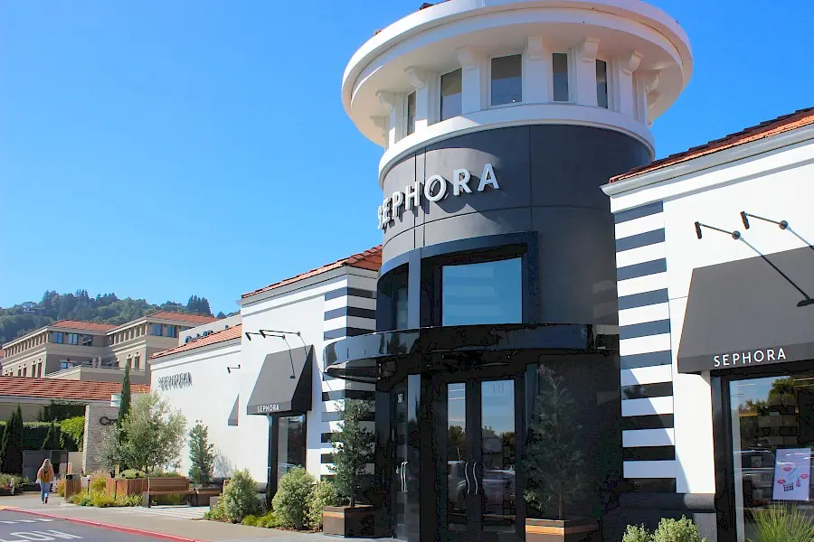 Exterior of a cozy arbora restaurant with outdoor seating and lush greenery.