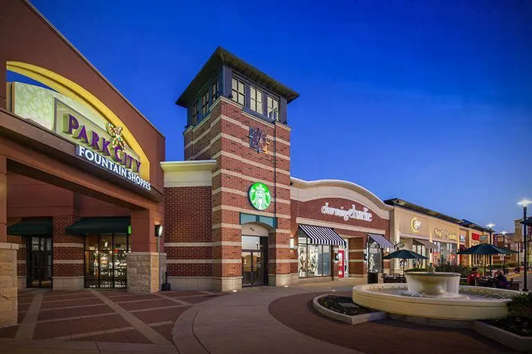 A shopping center with a fountain in front, offering a serene ambiance for visitors.