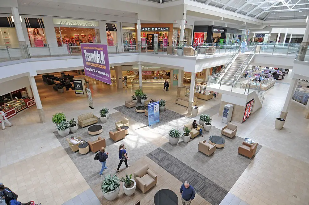 A bustling shopping mall with people strolling around, exploring various stores and enjoying their shopping experience.