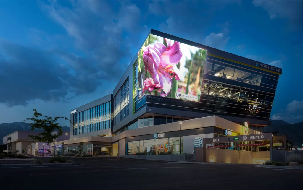 A tall building with a massive screen on its roof.