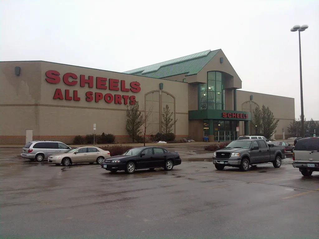 A parking lot filled with parked cars at Scheels Mall.