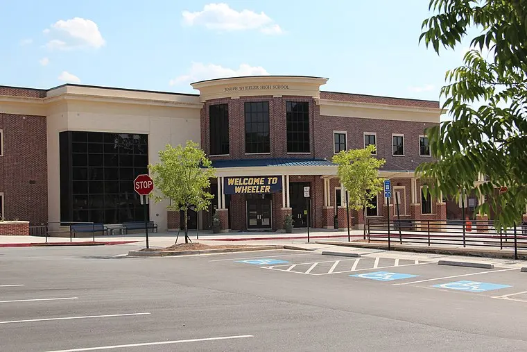 A shopping center with palm trees and a parking lot at Piedmont Commons Shopping Center Mall.