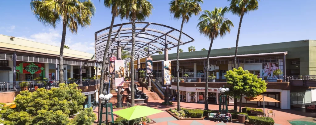 a shopping center in the city with palm trees