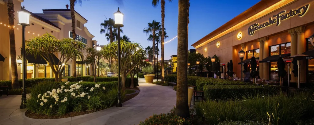 A walkway in front of Otay Ranch Town Center Mall with palm trees.