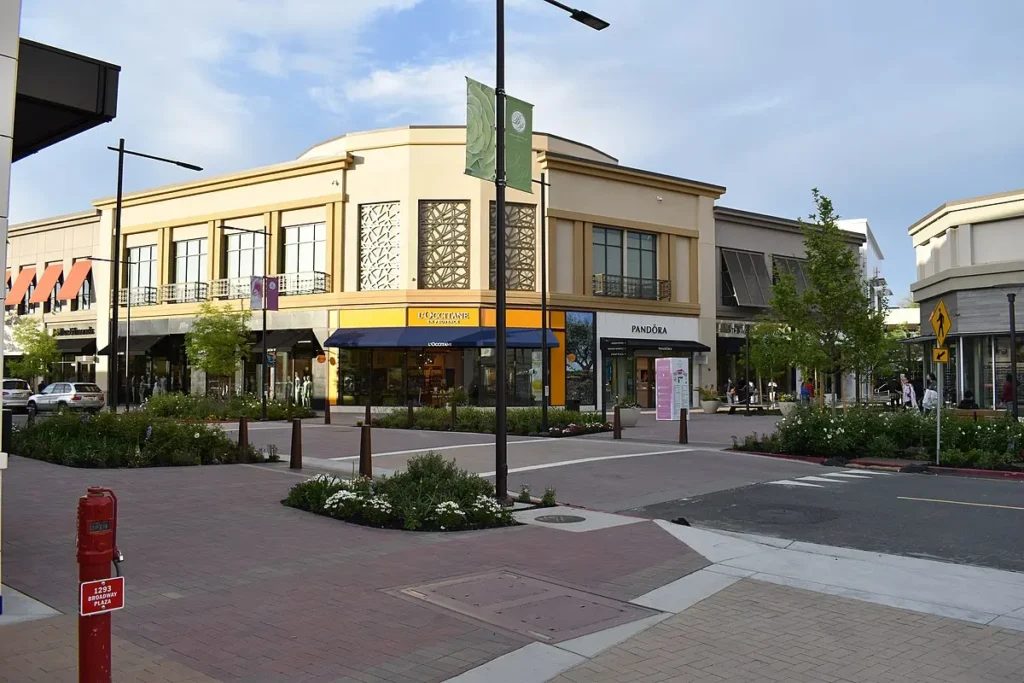 A street in Broadway Plaza with a fire hydrant and a few shops.