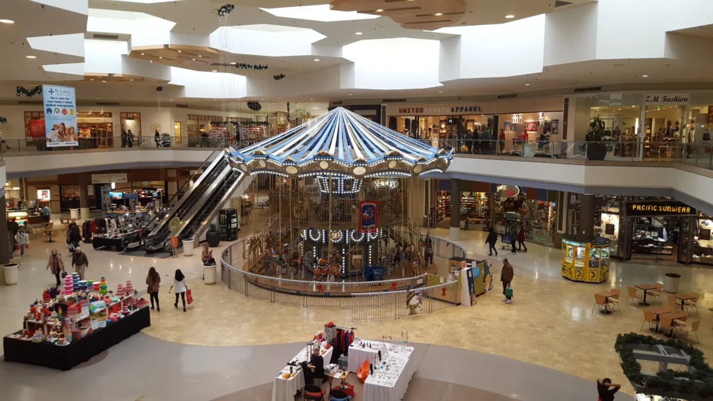 A bustling mall carousel with people walking around, enjoying a day of shopping and leisure.