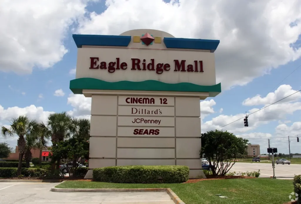 Exterior of Eagle Ridge Mall with palm trees and parking lot.