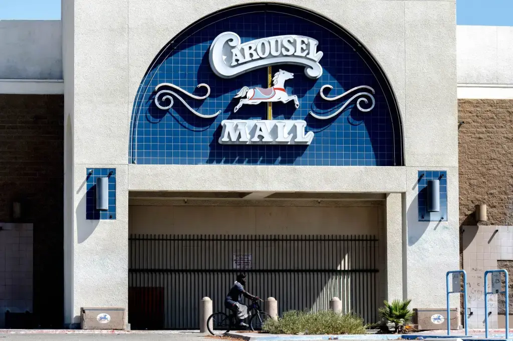 A man cycling past a closed Carousel Mall in Los Angeles