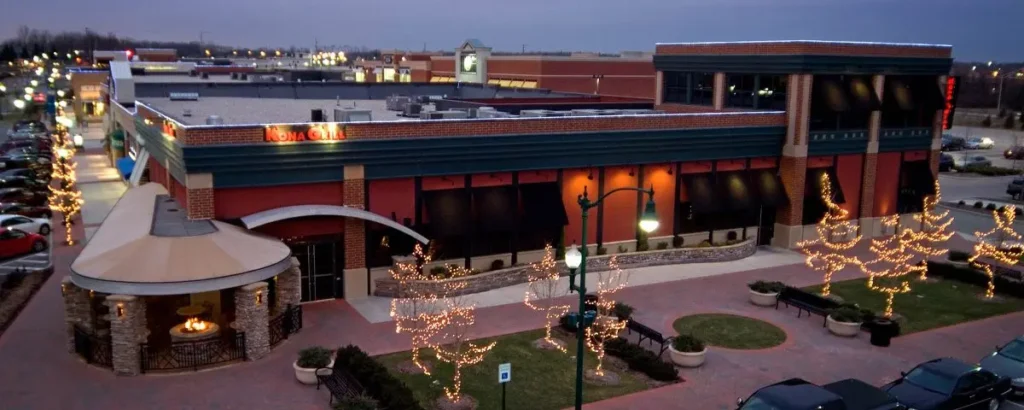 Exterior of Clay Terrace Mall with various stores and people walking around.