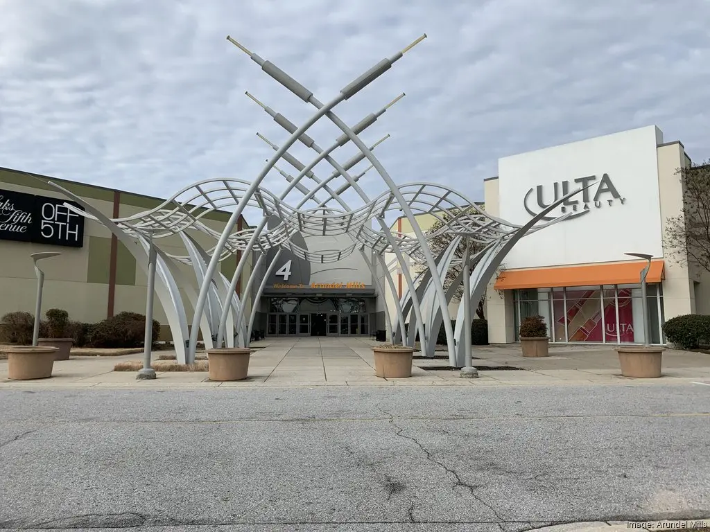 Entrance to Arundel Mills Mall with a prominent metal sculpture, during holiday hours