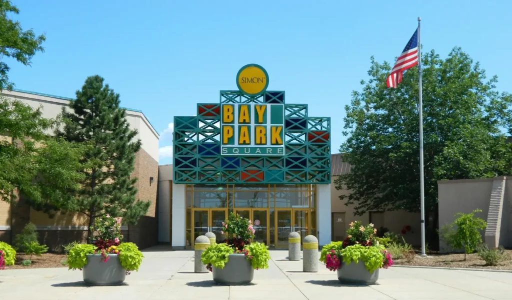 Busy shopping center, Bay Park Mall, with colorful storefronts and bustling shoppers.