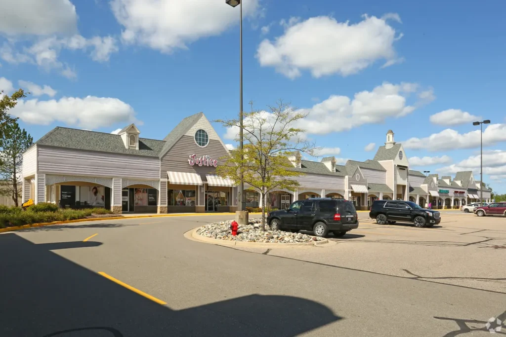 Exterior of Tanger Outlets Howell with parked cars in lot.