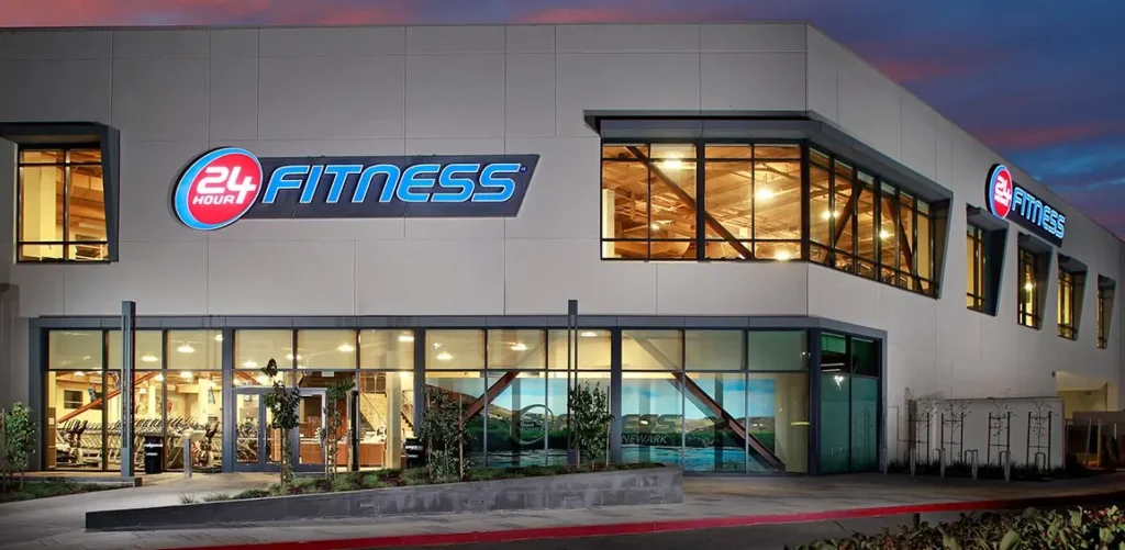 Exterior of 24 Hour Fitness Newpark Mall at dusk.