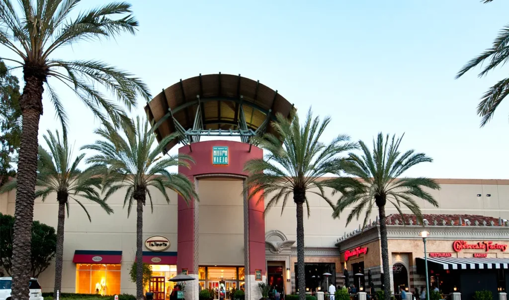 Exterior of The Shops at Mission Viejo Mall with palm trees in front.