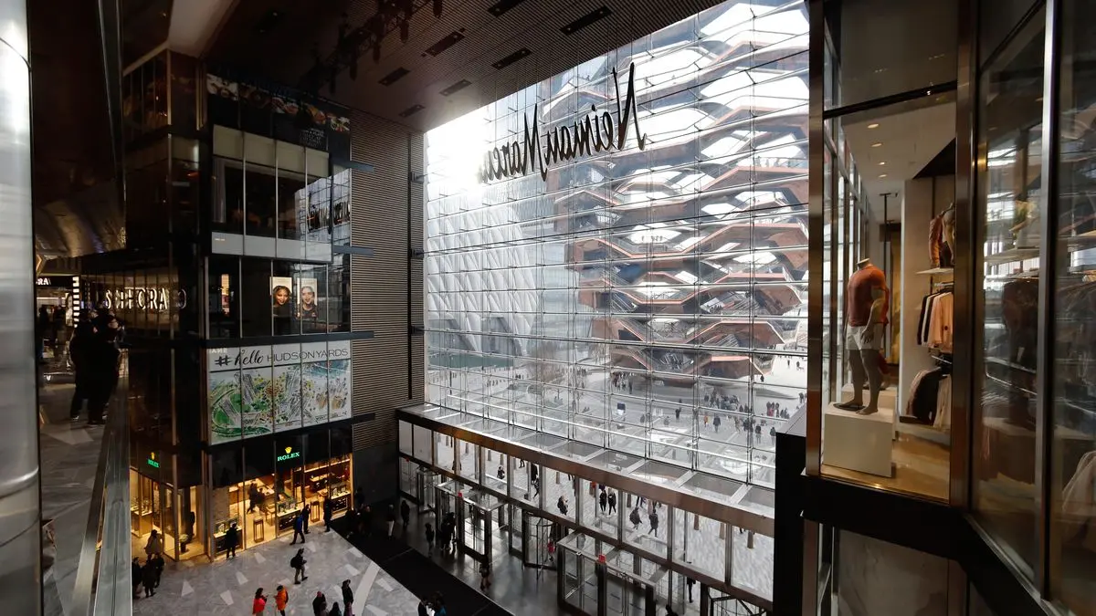 Glass-walled structure with pedestrians at Hudson Yards Mall.