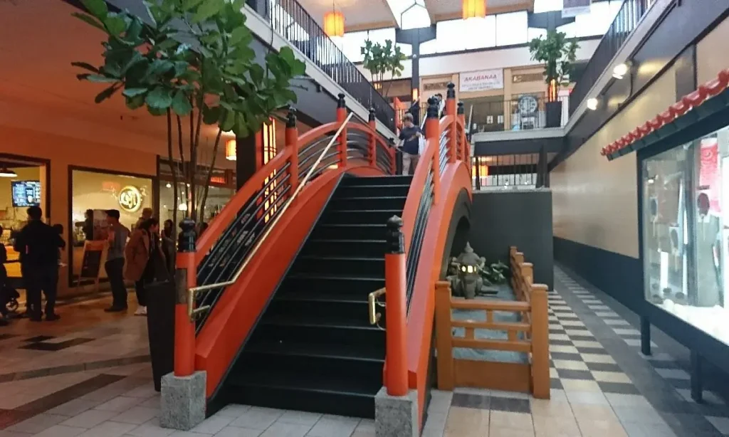 People descending stairway with orange railing at Japan Center Malls.